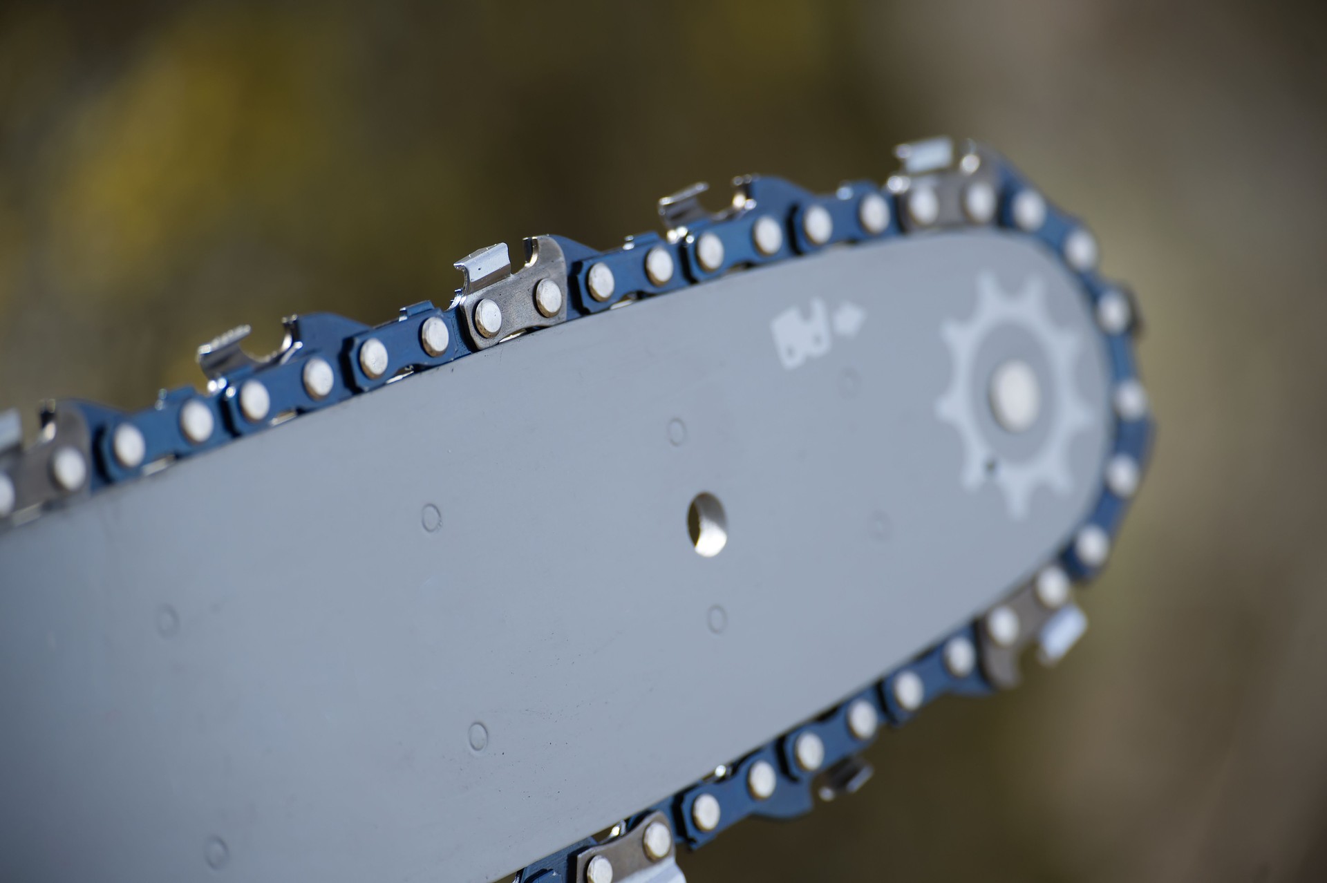 Detailed close-up showcases the sharp, metallic chain of a chainsaw in pristine condition.